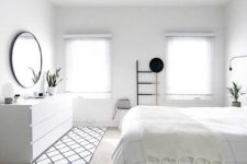 an airy Scandinavian bedroom with lot sof white, striped and tassel textiles, a black frame mirror, a sideboard