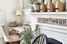 chic farmhouse spring mantel decor with greenery in bottles, potted greenery and more branches in vases