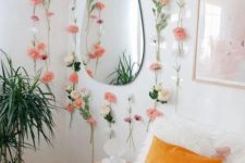 faux pink blooms attached to the wall and a marigold and peachy pillow make the bedroom spring-like