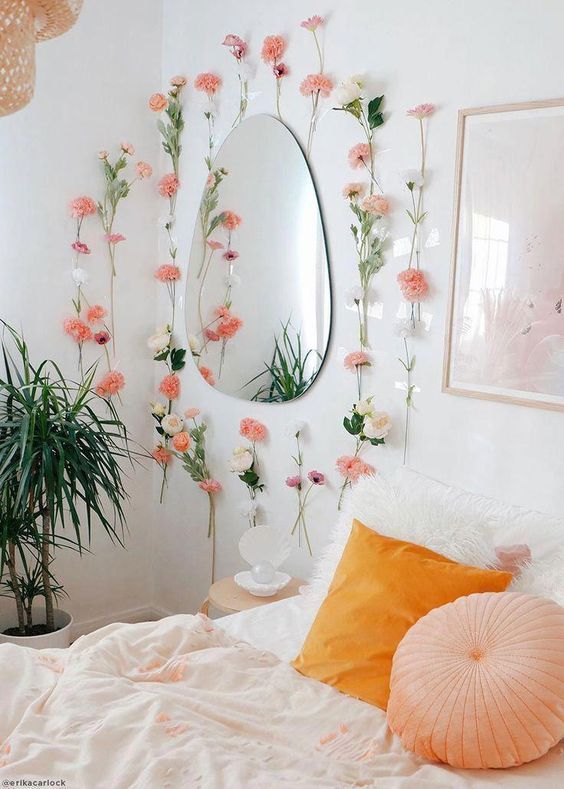 faux pink blooms attached to the wall and a marigold and peachy pillow make the bedroom spring-like