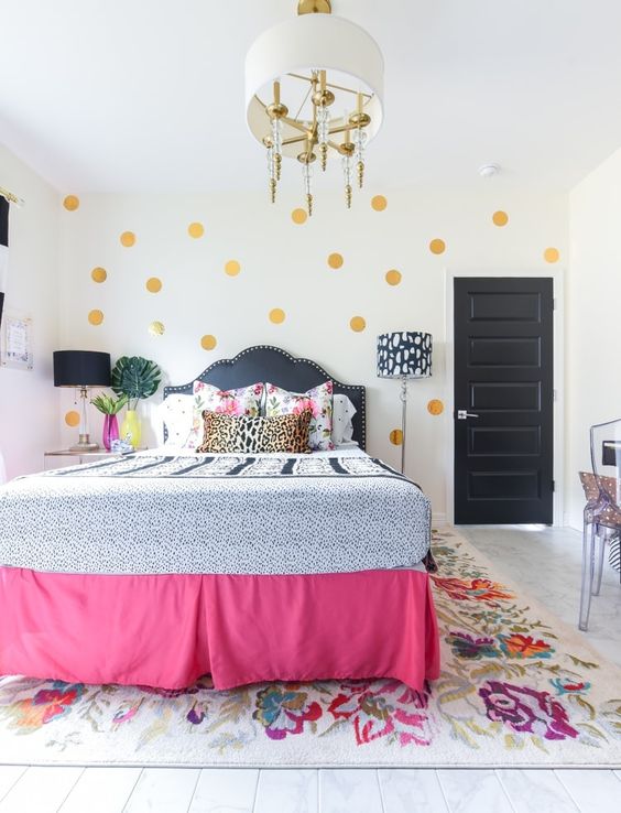 Gold polka dots, a pink bed cover, some floral bedding make the space feel very spring like