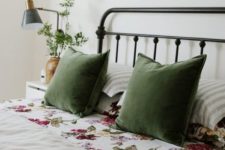 greenery in a vase, green pillows and floral bedding make the bedroom feel like spring or summer