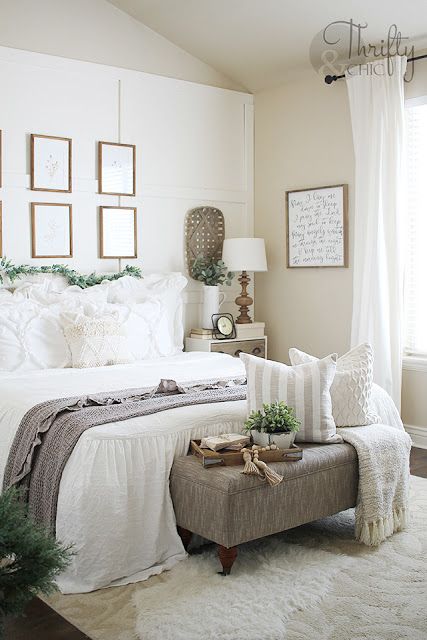 Potted greenery and a faux greeneyr garland make this neutral farmhouse bedroom refreshed and spring like