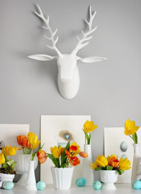 some faux speckled eggs, bright yellow tulip arrangements and egg artworks for an Easter mantel