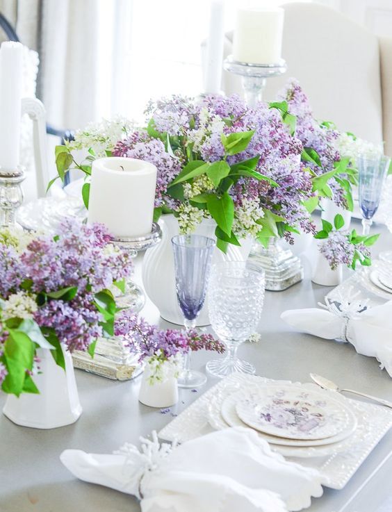 welcome spring with lush lilac centerpieces, candles, floral plates, white napkins and neutral cutlery