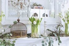 white bloom arrangements in clear vases, bird cages, fresh greenery and elegant candles