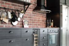 a black kitchen with a red brick backsplash is a stylish and bold idea for a masculine kitchen