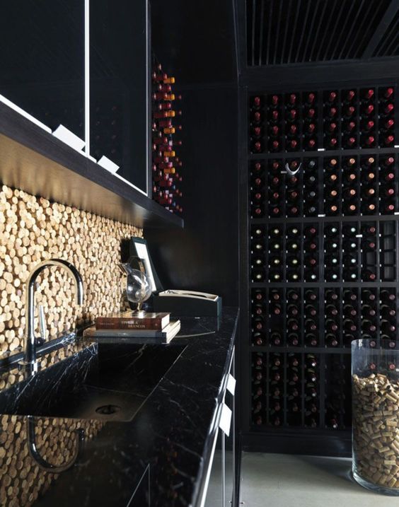 a black marble kitchen with a cork backsplash, a large wine cellar for a stylish moody masculine kitchen