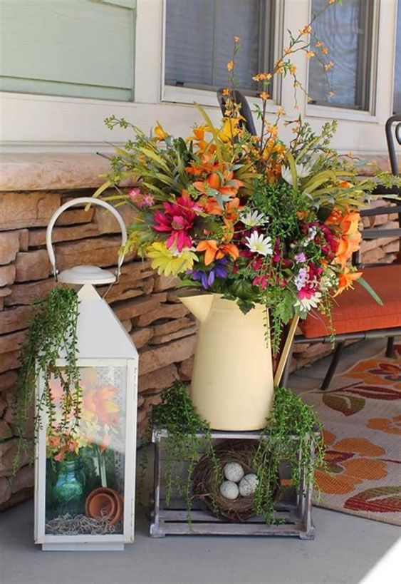 a bright decoration of a bold floral arrangement, a lantern with flowers, a faux nest with eggs and greenery