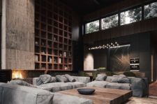 a contemporary masculine living room with dark walls, a large storage unit, a fireplace, grey sofas and a wooden table