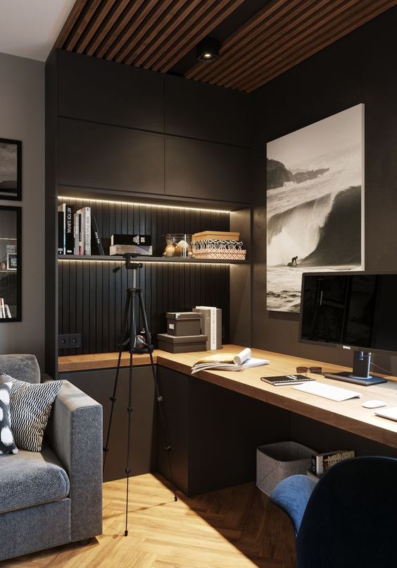 A contemporary moody home office with closed and open storage units, built in lights, a large desk and upholstered chairs