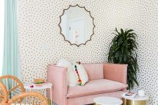 a lively living room with Dolmatin print walls, a pink loveseat, a rattan chair, shiny gold coffee tables and potted plants is amazing