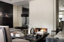 a luxurious masculine living room with white walls, grey and black furniture, a fireplace, lamps and artworks