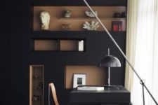 a mid-century modenr home office with a black wall, a rich stained niches, a black desk and stylish lamps