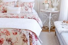 a refined Parisian style bedroom with chic furniture, floral bedding and a floral applique on the wall plus some blooms