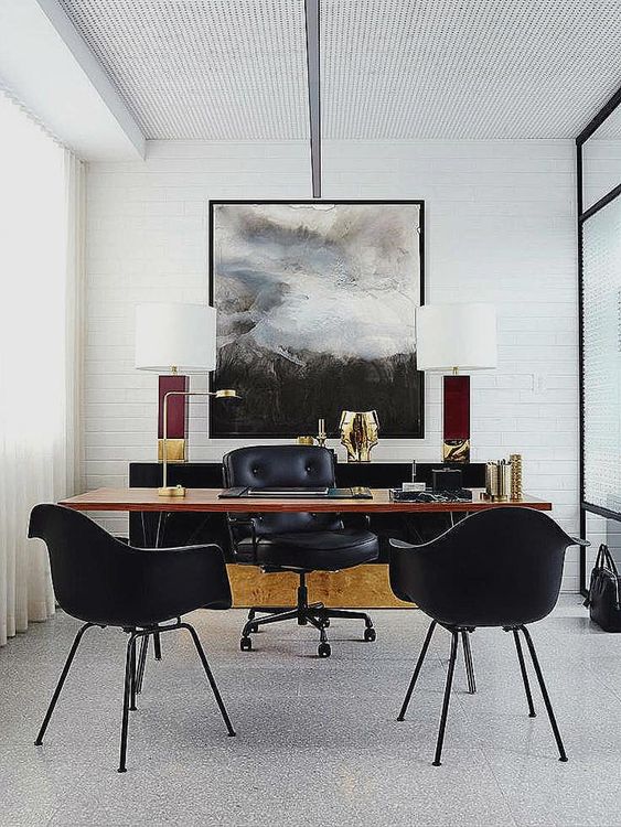 a stylish home office in neutrals with a black sideboard, a sleek wooden desk and black leather chairs for an elegant touch