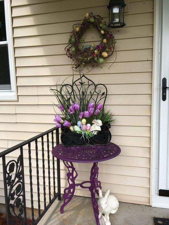a vine wreath with colorful eggs, potted blooms and faux eggs in a planter, fake bunnies for porch decor