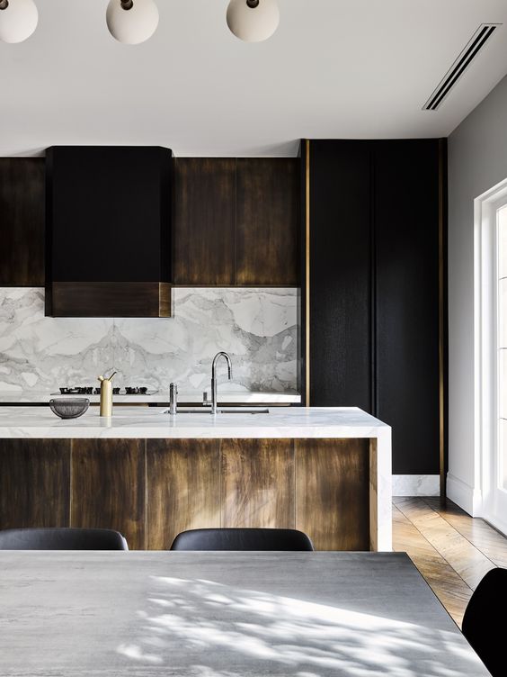 Black and light colored wooden cabinets, a marble backsplash and countertops for a chic touch
