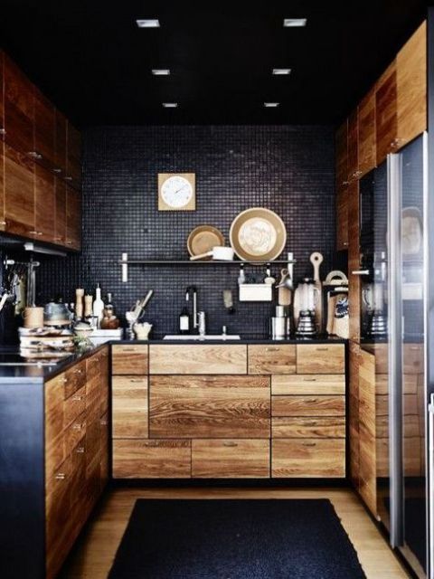 Light colored wooden cabinets with black metal countertops and blakc tile backsplashes for a contrasting look