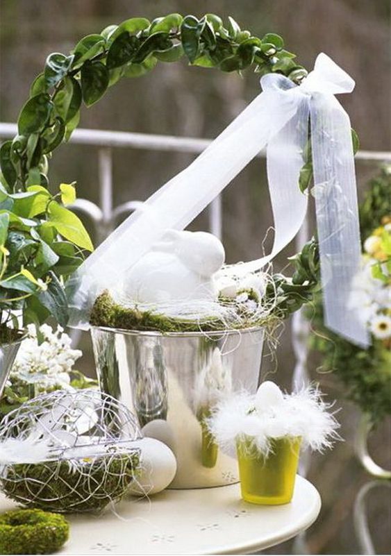 simple Easter decor with a bucket with greenery, a bow, some faux eggs and decorative ones