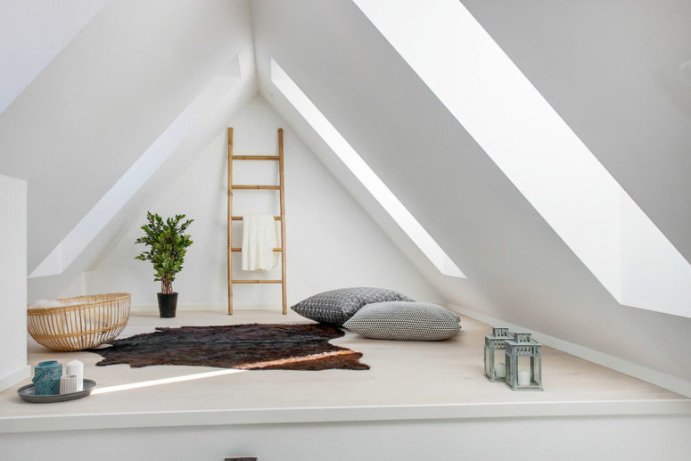 a small and minimalist attic space with a rug, pillows and candle lanterns  (Busy Bees ApS)