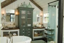 a barn bathtub in white, with stained wooden beams, an elegant free-standing tub, vintage furniture and a glass enclosed shower