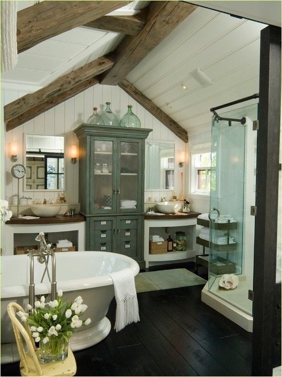 a barn bathtub in white, with stained wooden beams, an elegant free-standing tub, vintage furniture and a glass enclosed shower