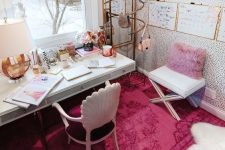 a bold feminine home office with a refined plum chair, a hot pink rug and pillow, a cool gallery wall and touches of gold