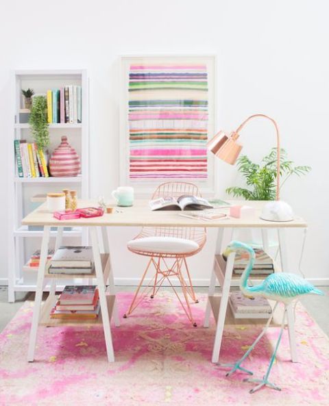 a bright feminine home office with a striped artwork, a colorful rug, a blue flamingo and touches of copper here and there