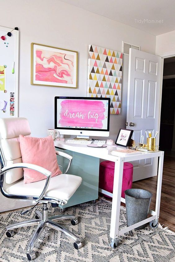 a bright home office with a white desk and chair, a pink pillows and a colorful gallery wall plus a purple stool