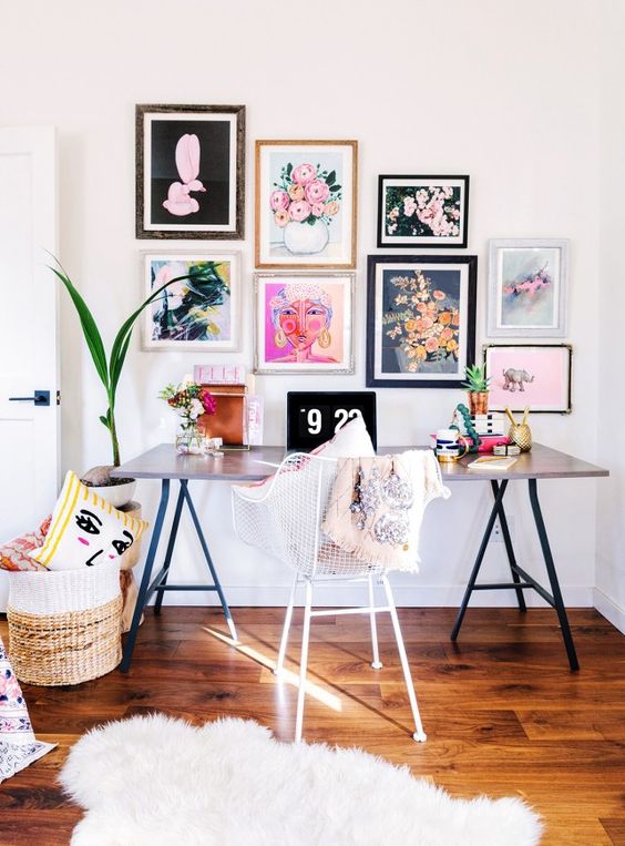 a colorful and fun girlish home office with a comfy desk, a bright gallery wall, a basket with pillows and a fur rug