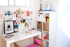 a colorful feminine home office with a hot pink stool, a gold scale pendant lamp and a bright gallery wall