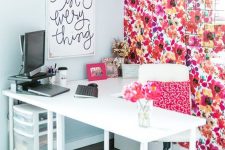 a colorful home office with a statement floral wall and a pillow and all white everything is bright and fun