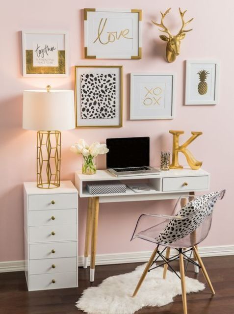a glam feminine home office with a blush accent wall, white furniture, a glam gallery wall and lots of gold