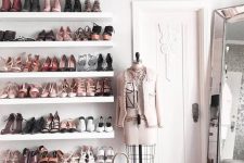 a lovely and glam feminine closet with open shelves, a grey storage pouf, a large mirror and touches of blush pink
