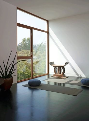 a minimalist meditation room with a large window for views and some mats and cushions