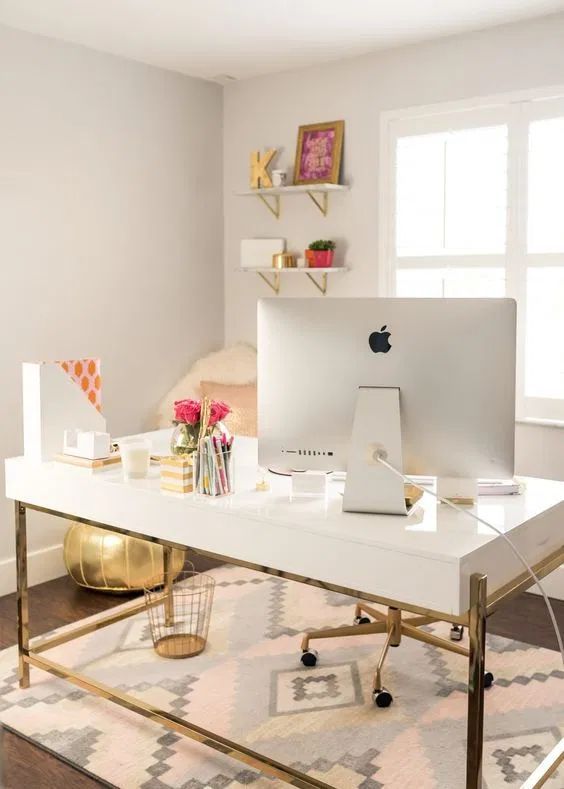 a refined feminine home office with a printed rug, neutral furniture, open shelves and touches of gold