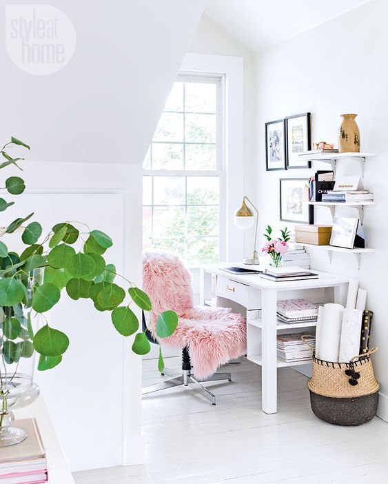 a small airy home office with a comfy desk and chair, some shelves, a basket and a gallery wall