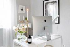a sophisticated feminine home office with white and grey furniture, a crystal chandelier and touches of gold