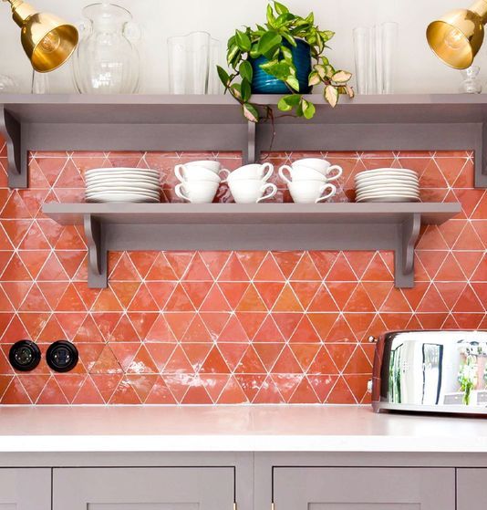 a super bold orange geo tile backsplash is a bold solution for a modern kitchen, it will add much color to the space