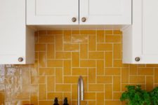 a white shaker style kitchen with a bold yellow tile backsplash that makes a color statement and creates a mood in the space