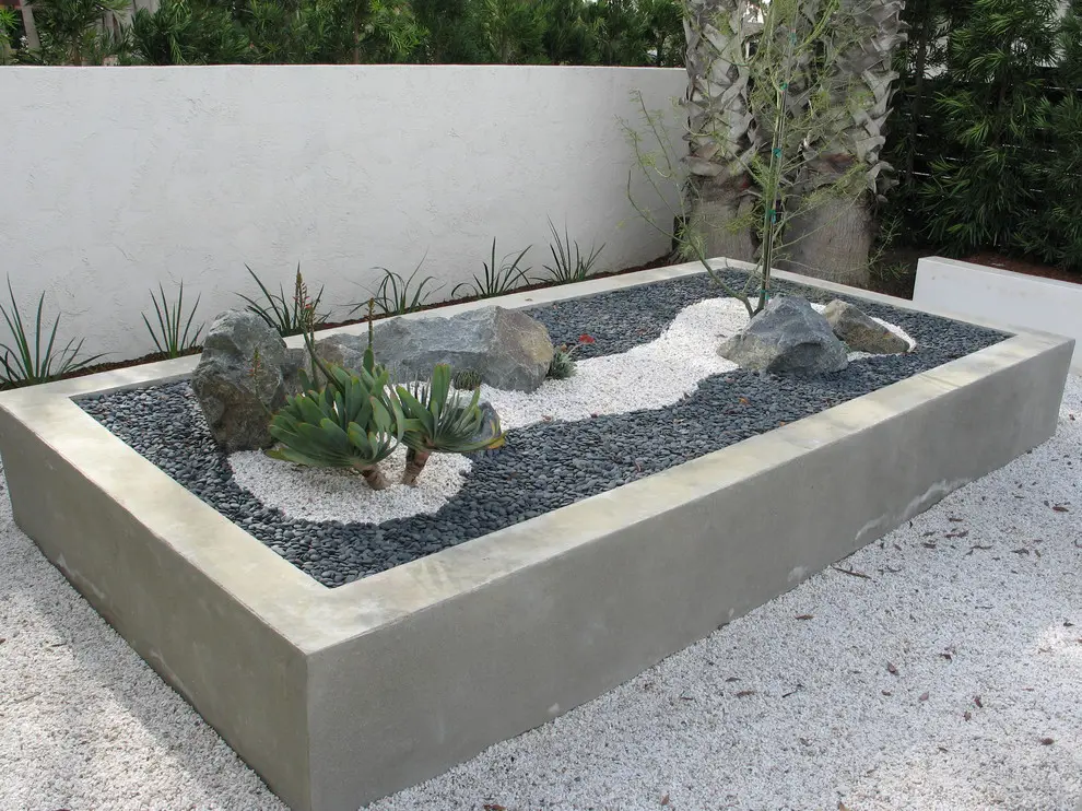 In sunny areas you could use succulents for a desert zen garden. 