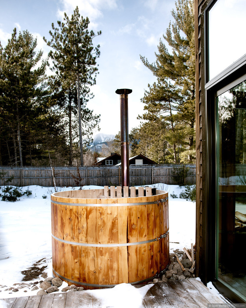 A small cedar hot tub on a deck is more than enough to enjoy view of mountains and woods around (Haas Habitats LLC)