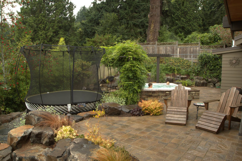 a built-in spa is a great way for adults to relax while kids are jumping on a trampoline (Alderwood Landscape Architecture and Construction)