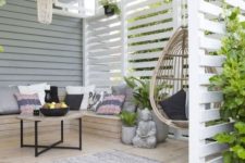 a boho and zen deck with a built-in bench, a rattan hanging chair, a bead chandelier, a coffee table and a jute ottoman