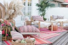a boho deck with rattan furniture, pampas grass, greenery in a pot, candles and lots of floral arrangements
