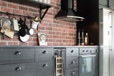a bold kitchen with dark wooden cabinets and red brick walls for a catchy look with a vintage feel