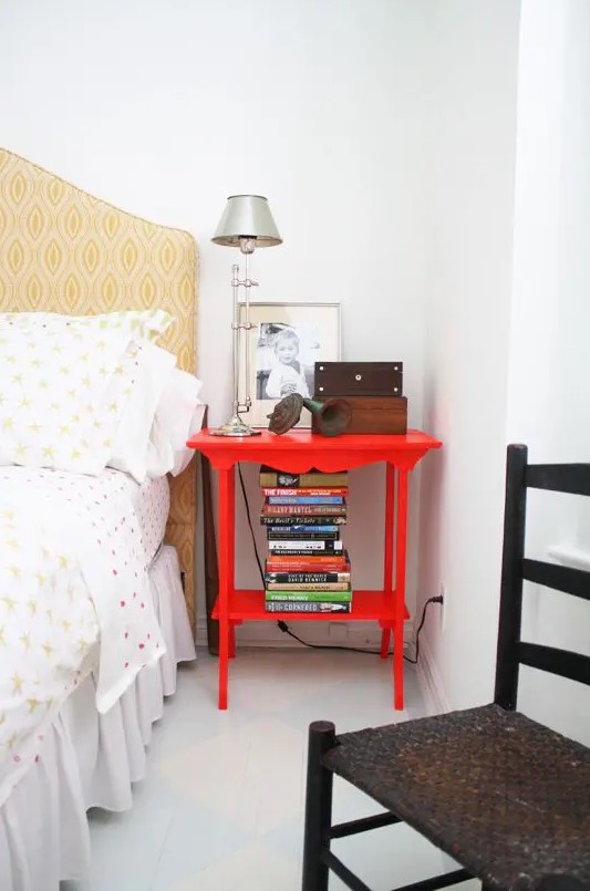 a bright red nightstand matches the bedroom style but adds a touch of super bold color