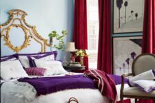 a colorful bedroom with blue walls, a bed with purple and white bedding, a vintage chair, red curtains, a red printed rug and a red blanket