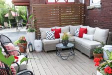 a colorful summer deck with a sectional sofa, potted greenery and blooms, rattan chairs and lanterns